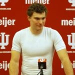 Young athlete speaking at a press conference with IU backdrop.